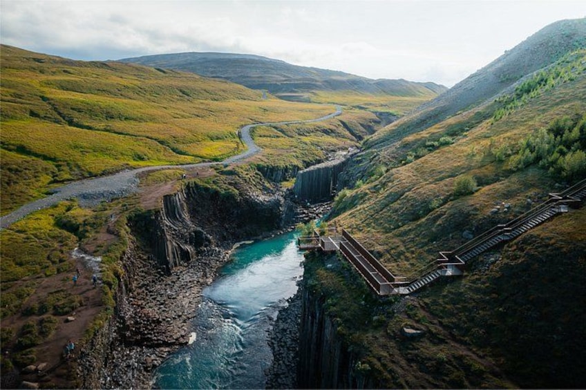 Un río que serpentea por un valle con un puente y una carretera. 4