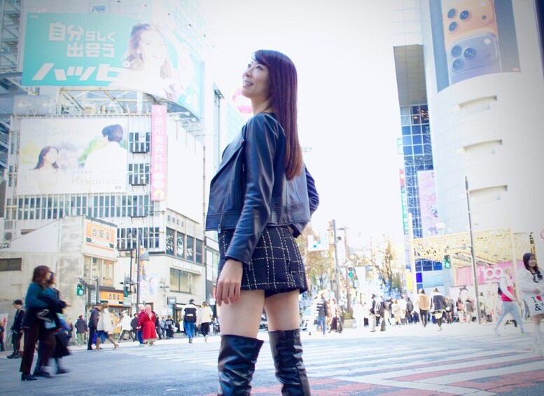 A person walking on a busy urban street with tall buildings and billboards. 2