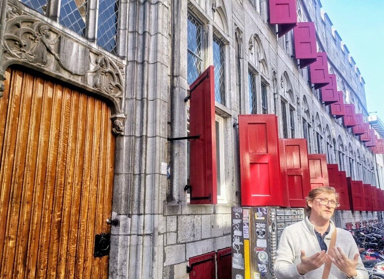 A street with a building featuring a wooden door and red shutters. 2
