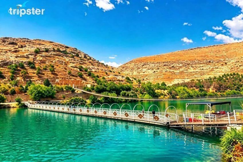 A boat on a turquoise river, a white bridge, and a hilly landscape. 5