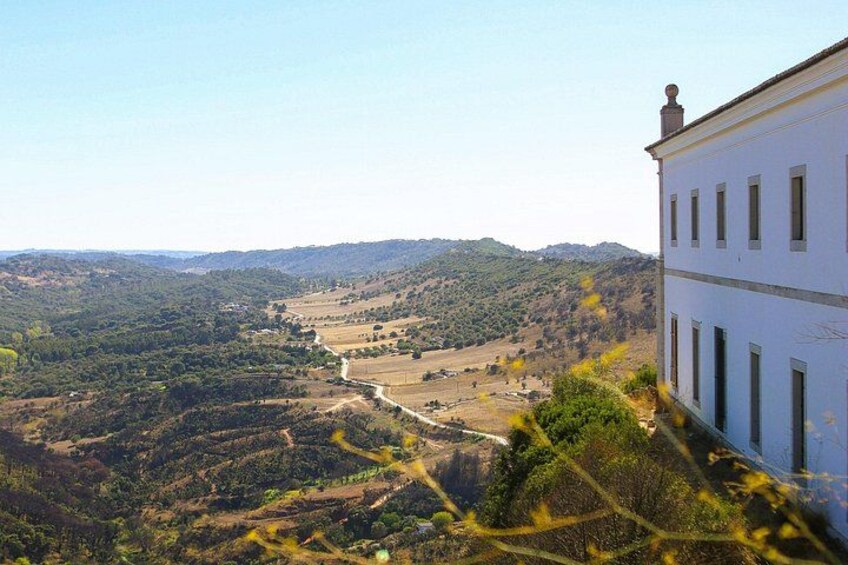 Une colline avec un bâtiment blanc, une vallée et une rivière. 2