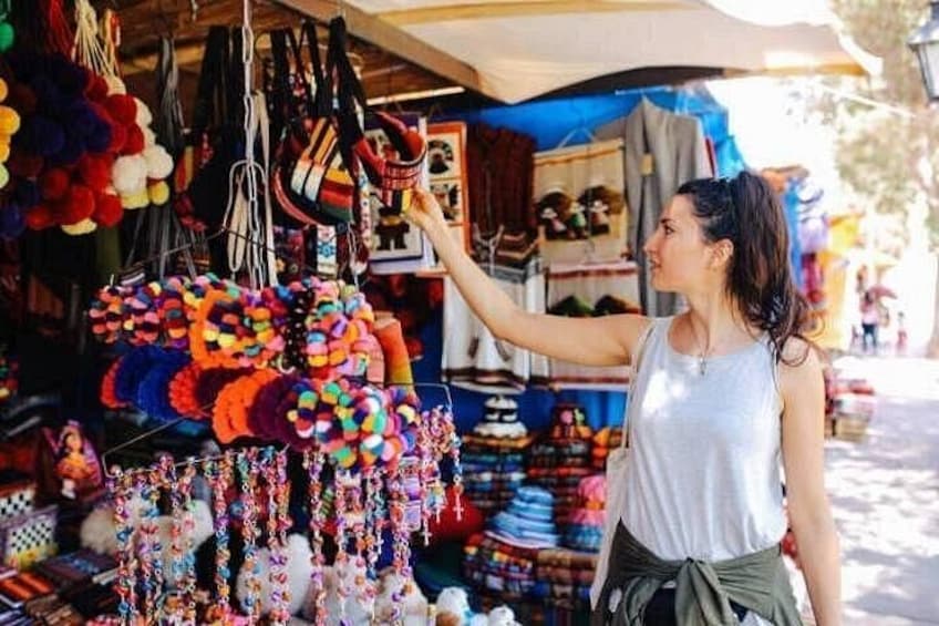 A person taking a photo at a market stall with colorful items on display. 4