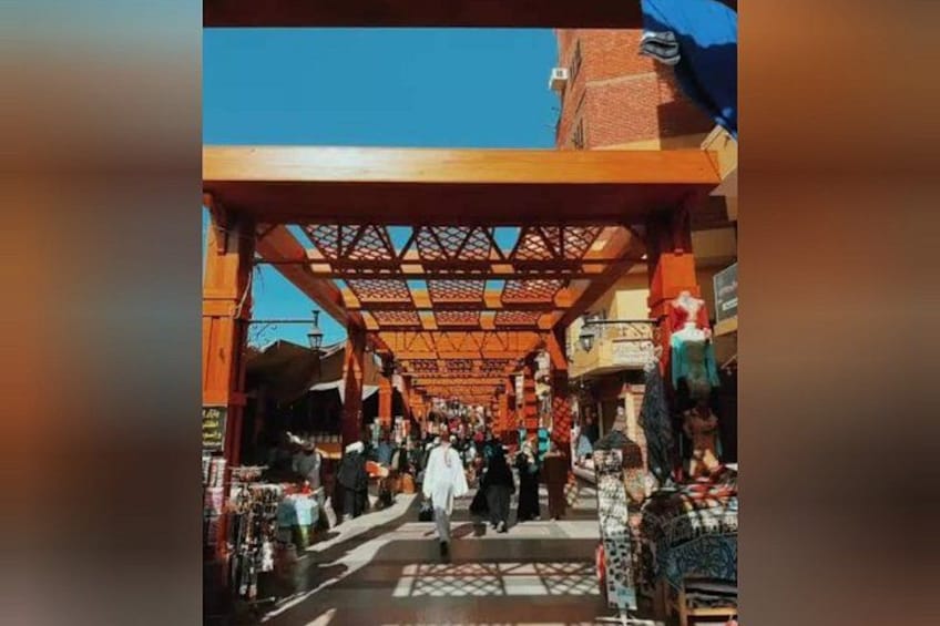 A covered market with wooden beams and stalls selling various goods. 5