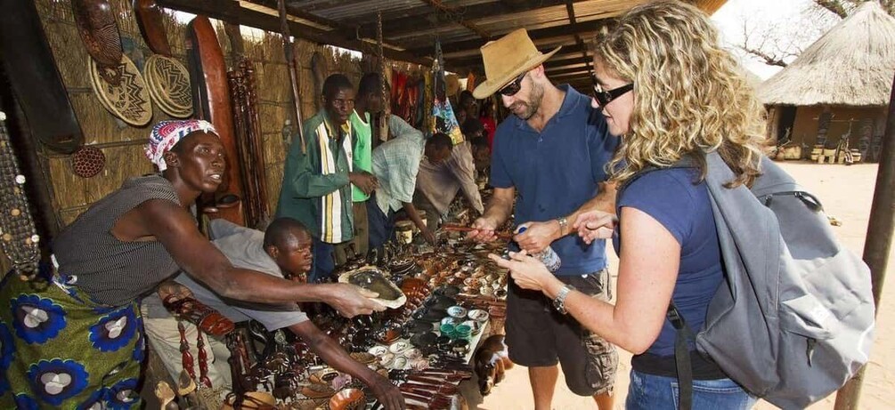 A market scene with people browsing and buying items. 5