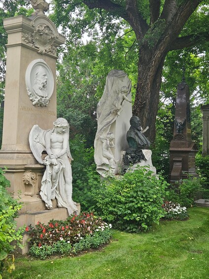 A statue of a man with a beard, a statue of a woman, and a statue of a child climbing a pillar. 3