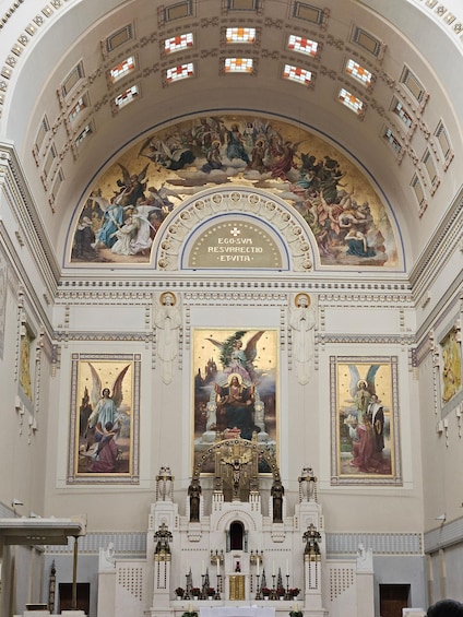 A church interior with a large fresco, ornate ceiling, and religious statues. 5