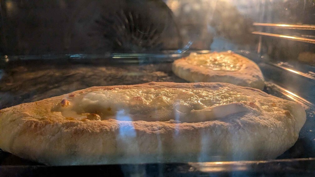 Une pizza à l’intérieur d’une cloche de verre, de la vapeur s’en échappant, ce qui indique qu’elle est chaude. 2