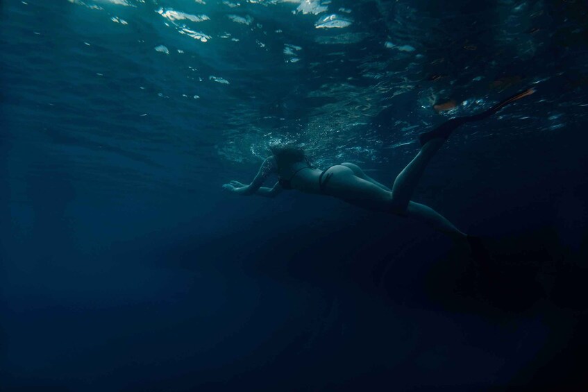 A person swimming underwater. 5