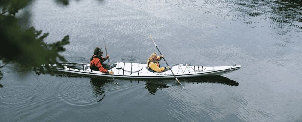 Two people in a canoe on a calm body of water. 3