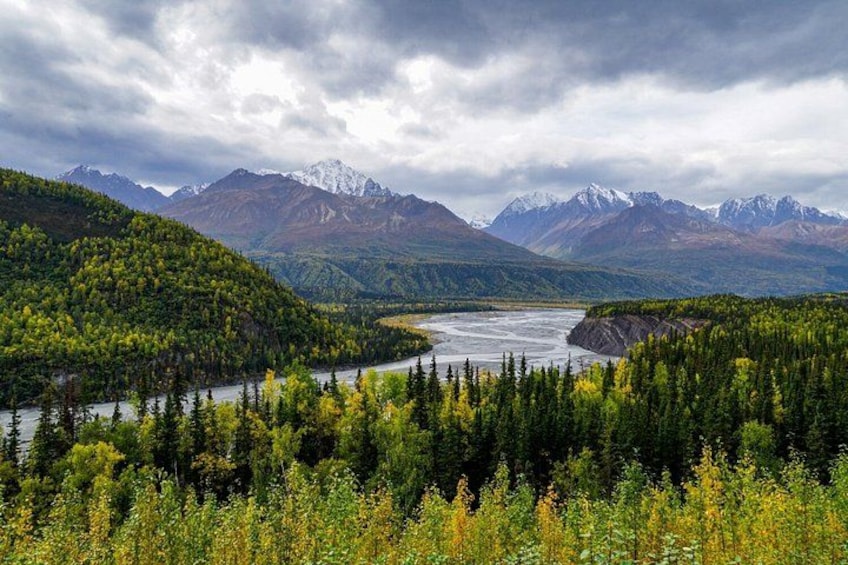A river winding through a forested valley with mountains in the background. 2