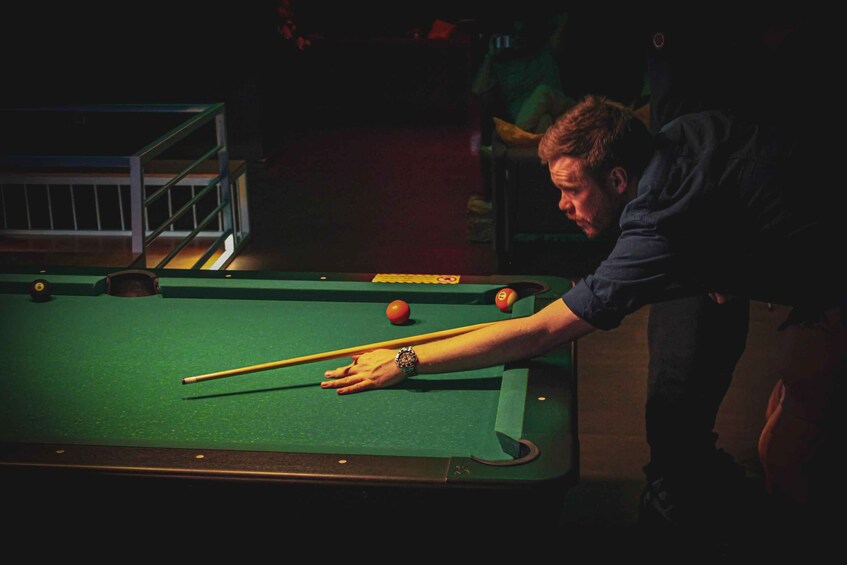 A person playing pool at a table. 4