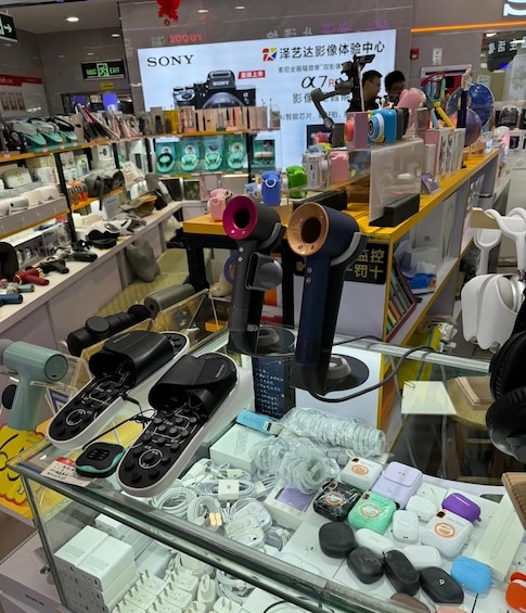 A store display with various electronic devices and accessories, including headphones, microphones, and cables. 4