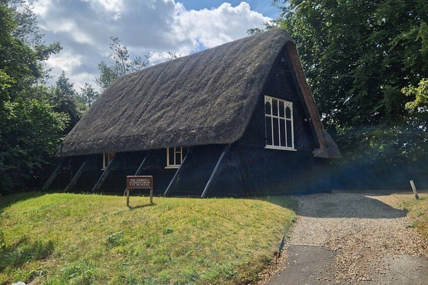 Ein Haus mit einem Strohdach und einem Schild davor. 5