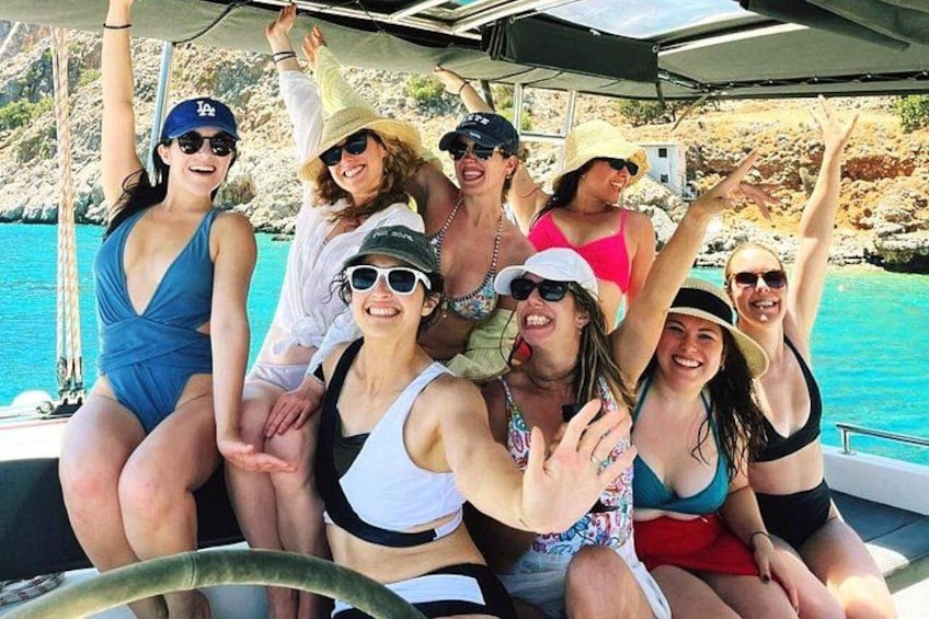 Un grupo de personas en un barco, con una costa rocosa al fondo. 5