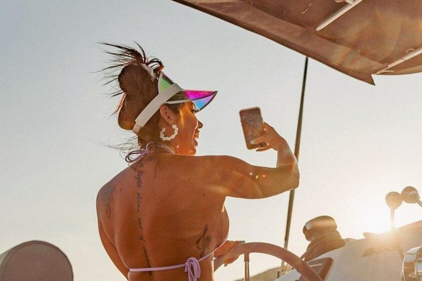 Una persona tomándose un selfie con un teléfono inteligente, usando un bikini y una diadema. 4