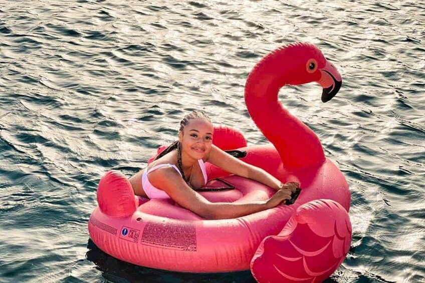 Eine Person treibt auf einem pinken Flamingo-Beckenreif in Wasser. 3