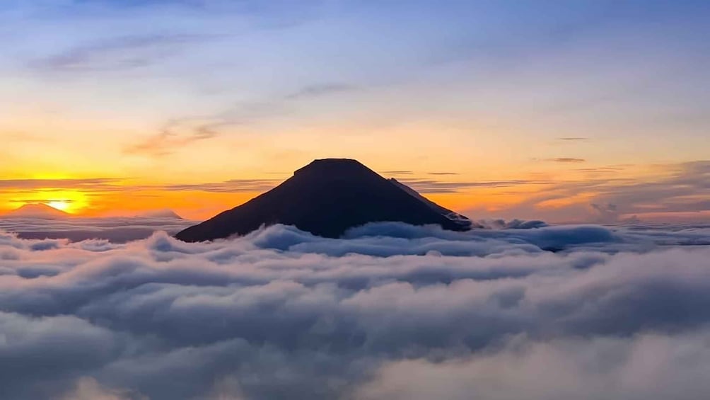 A mountain peak above clouds at sunrise. 2