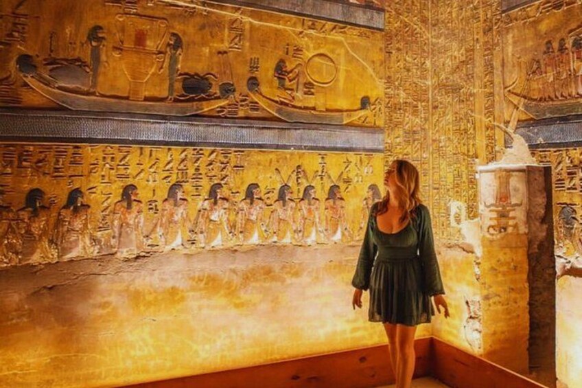 A person standing in a room with ancient Egyptian wall paintings and hieroglyphs. 4