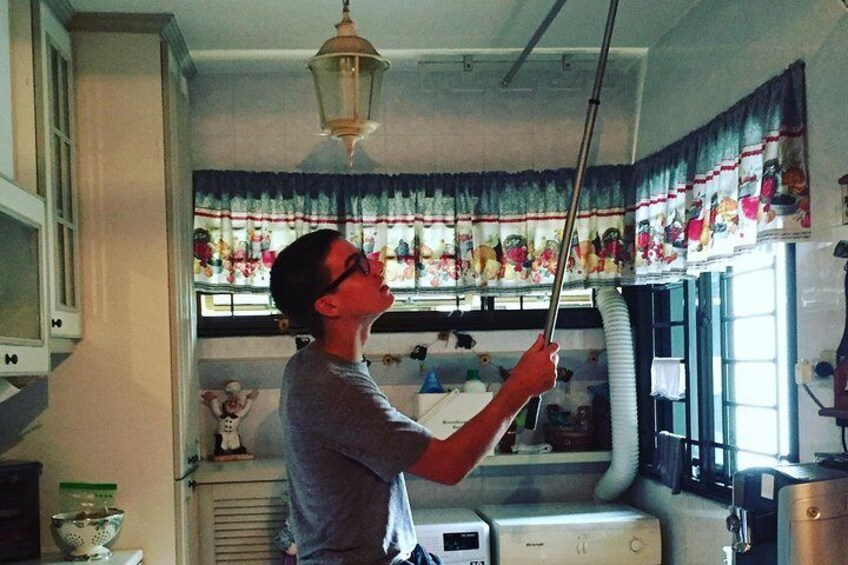 Una persona limpiando una ventana con un gubia en una cocina. 1