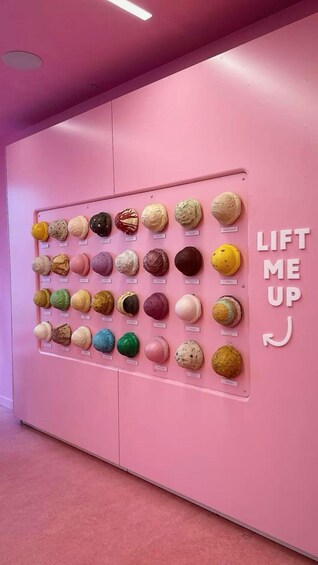 A pink wall with a grid of colorful ice cream balls and the text "LIFT ME UP". 4