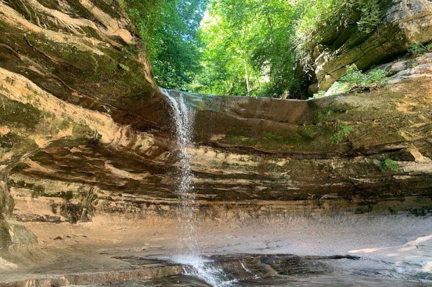 Une cascade se déversant le long d’une falaise rocheuse, entourée d’une végétation luxuriante. 1