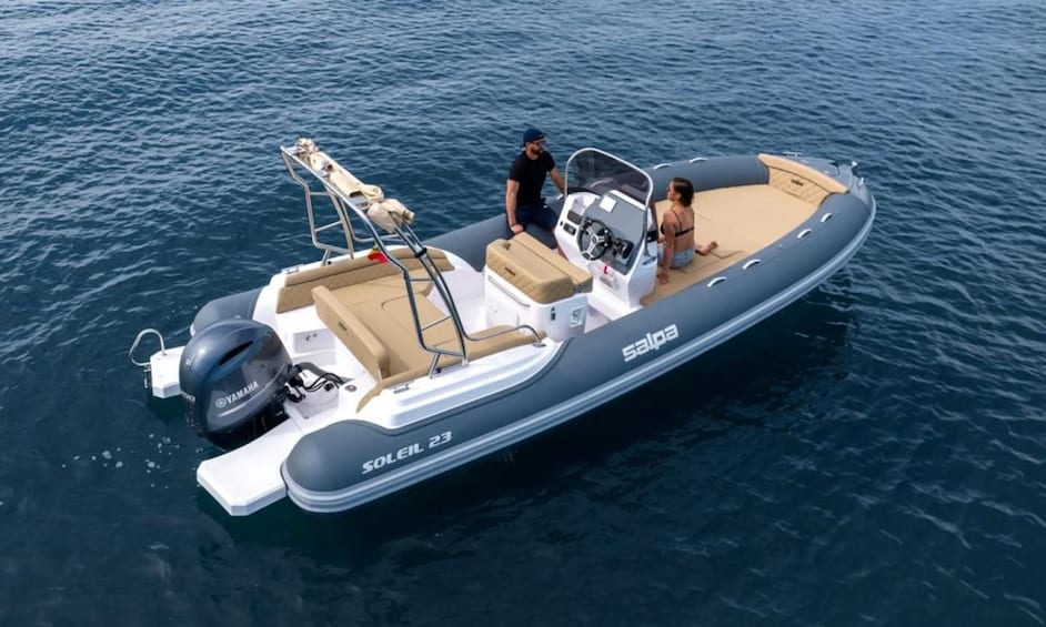 Un petit bateau à moteur avec deux personnes à bord, un moteur hors-bord Yamaha et le nom de marque « SOLEIL 23 » inscrit sur le côté. 2