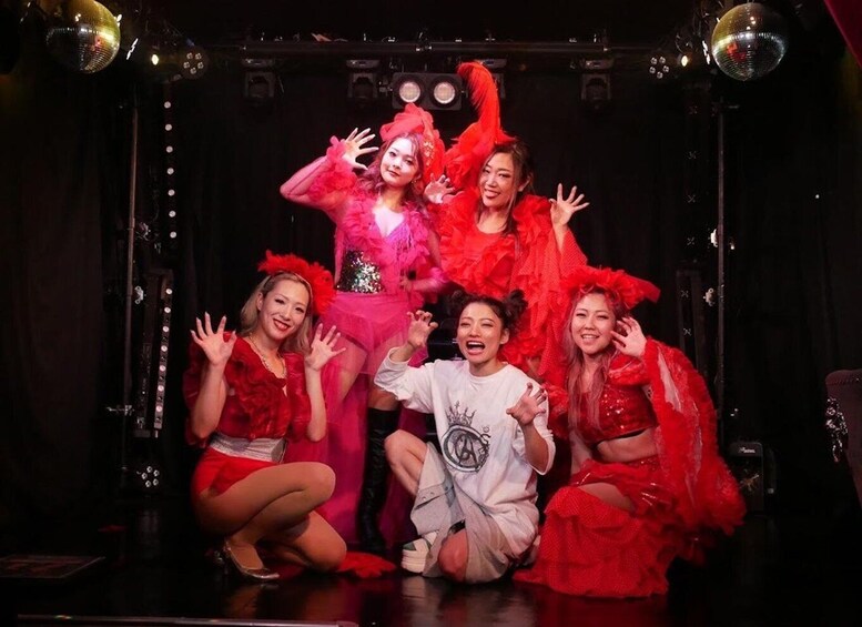 A group of people in a stage setting with disco balls and stage lighting. 2