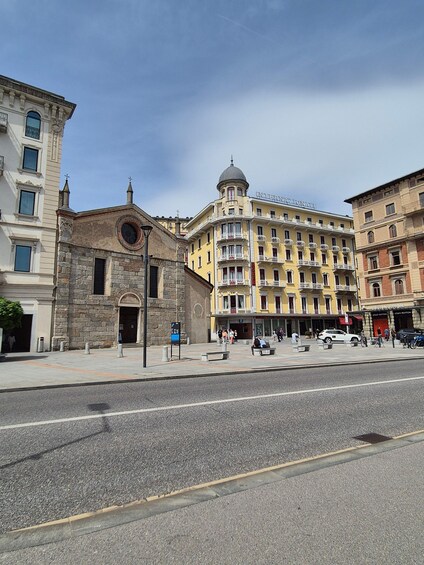 A street with a historic building, a modern hotel, and a Louis Vuitton store. 2