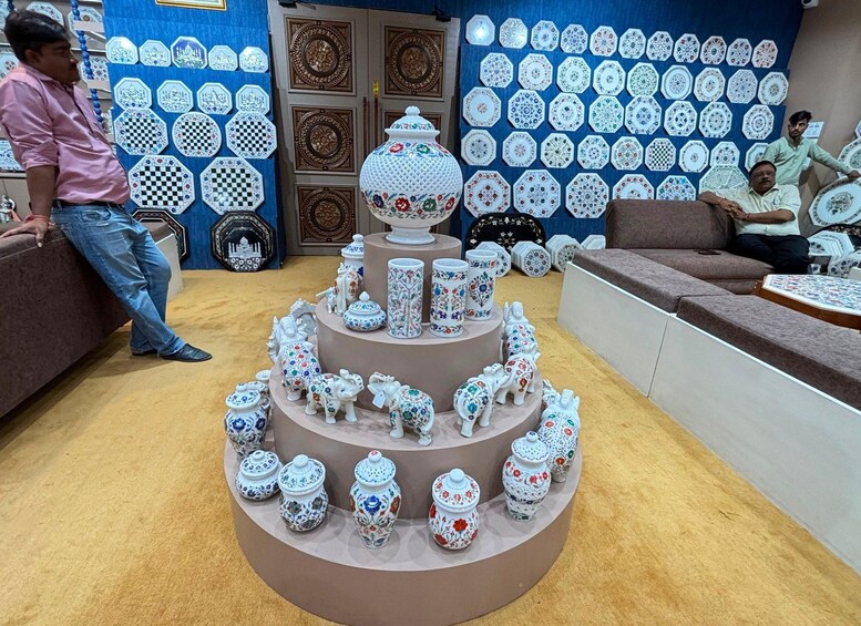 A display of ceramic items with a central tiered stand and decorative plates on the wall. 3
