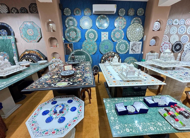 A room with tables covered in ornate, patterned tablecloths and surrounded by shelves of decorative plates. 1