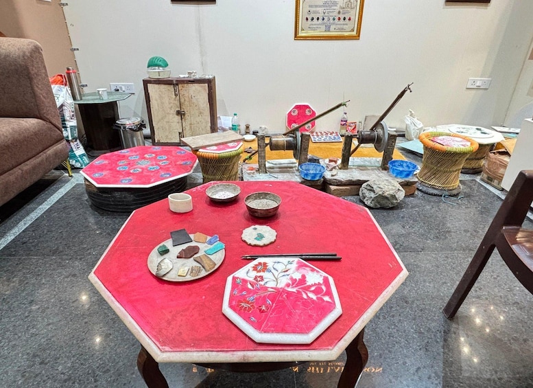 A room with a red octagonal table, various pottery items, and a traditional loom. 2