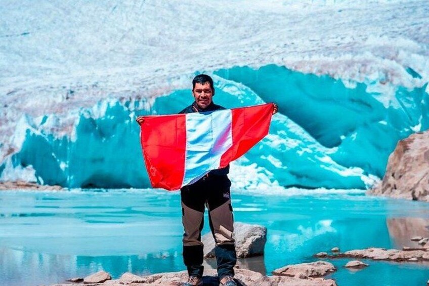 A person standing in front of a glacier with a flag. 2