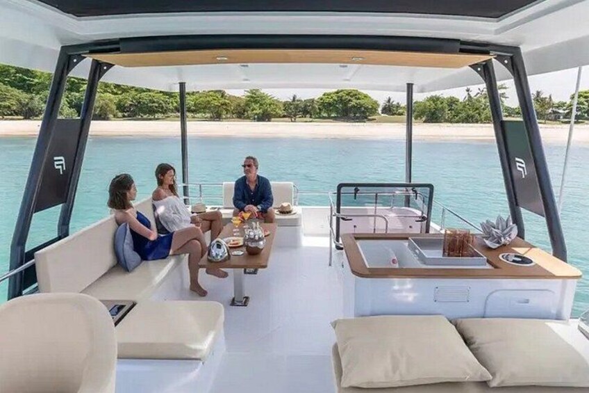 A yacht with a dining area and a view of a beach. 5