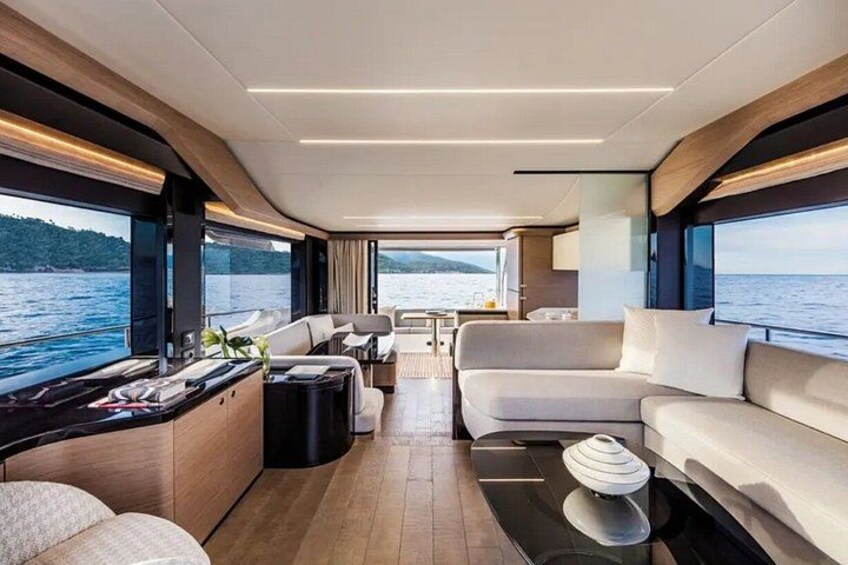 Een luxueus interieur met een bank, een eethoek en uitzicht op het water. 5