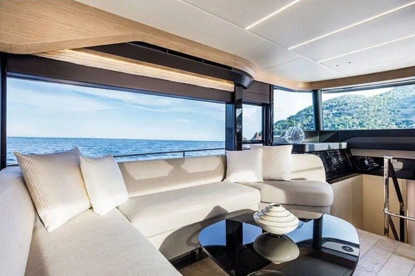 Een modern jachtinterieur met een bank, een bijzettafeltje en uitzicht op zee. 3