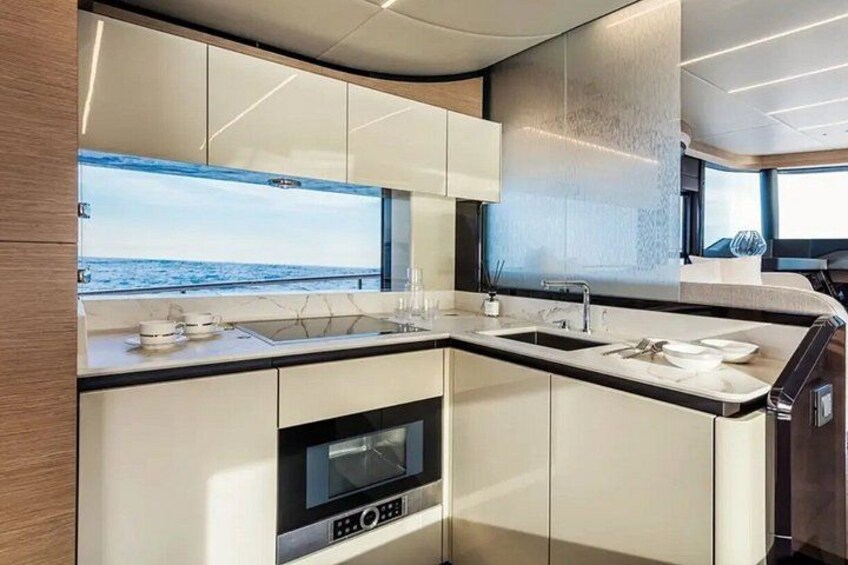Een moderne keuken met uitzicht op zee, met een inbouwoven en een groot raam. 2