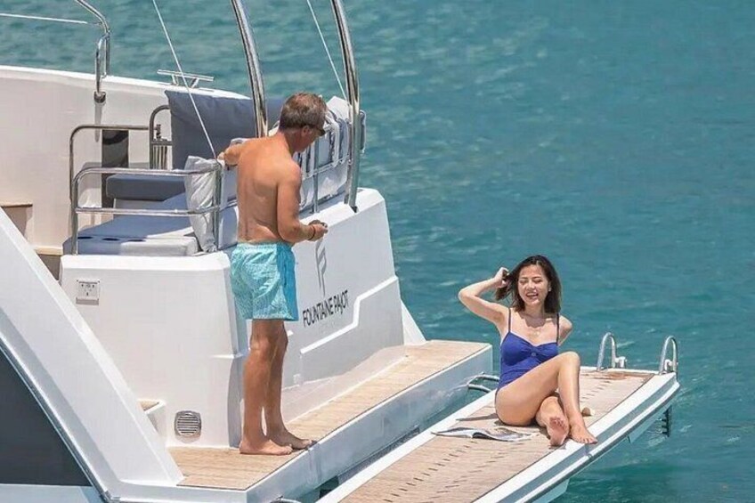 Un yacht sur lequel une femme est assise sur le pont et un homme est debout. 5