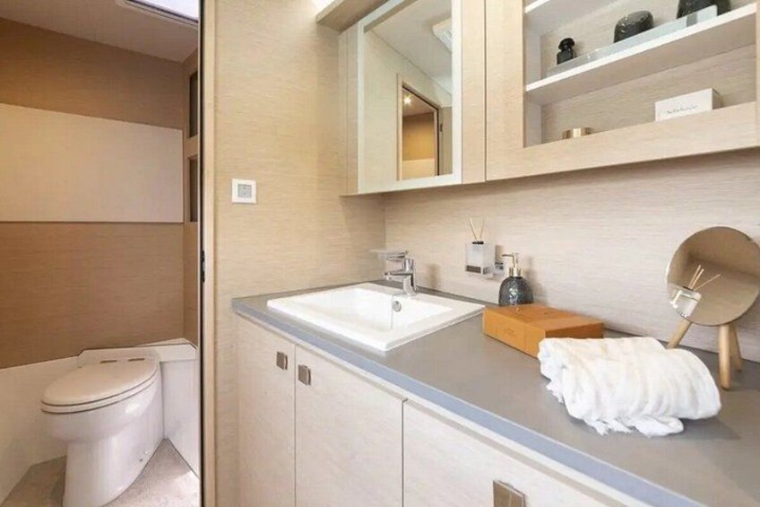Een moderne badkamer met toilet, wastafel, spiegel en planken. 3