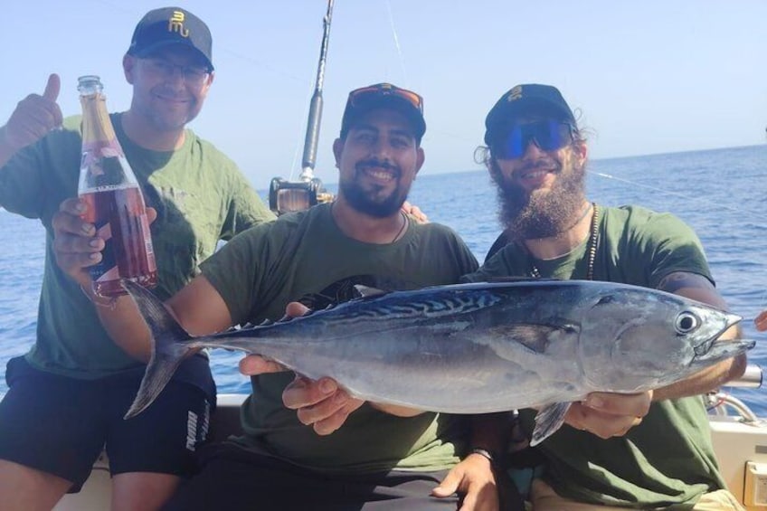 Drie mensen in een boot met een grote vis. 2