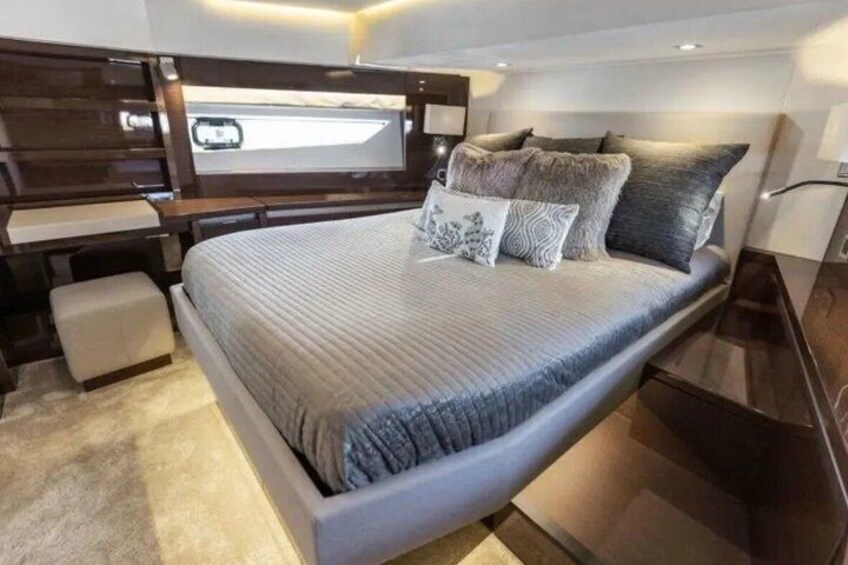 A modern bedroom with a large bed, dark wood headboard, and a bedside table. 3