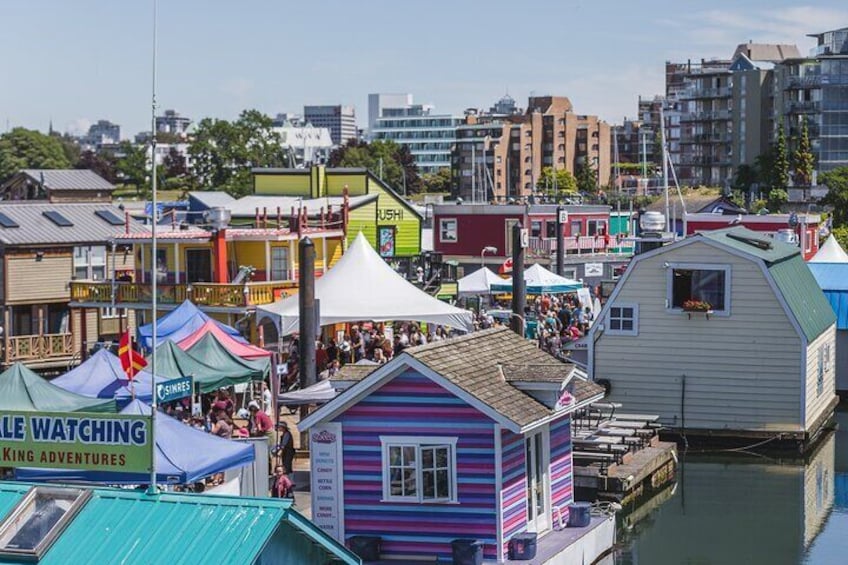 Een markt aan het water met kleurrijke gebouwen en tenten. 5