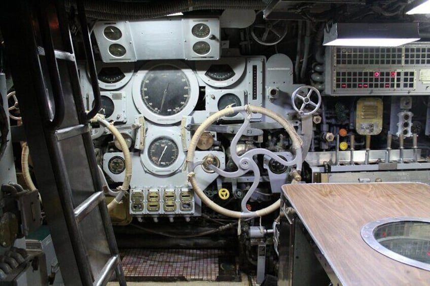 A control panel with multiple gauges, dials, and switches, indicating a technical or industrial setting. 5