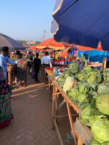 A bustling outdoor market with vendors selling fresh produce under colorful umbrellas. 3