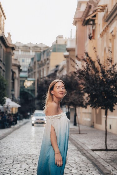 A person standing on a cobblestone street in a historic urban area. 3