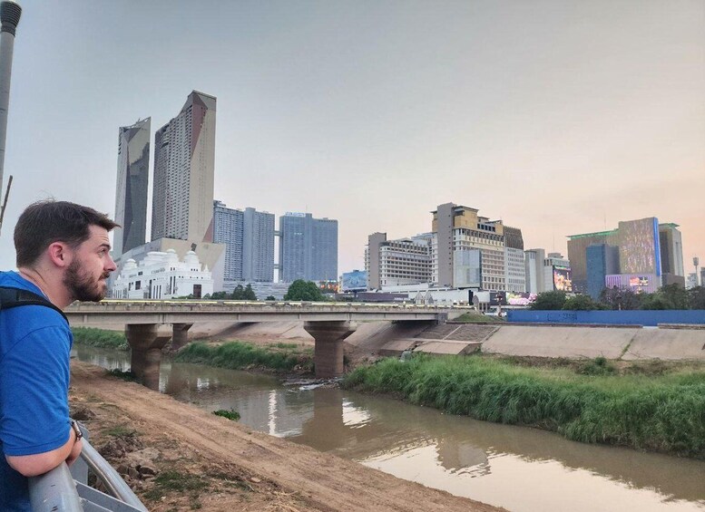 A person overlooking a river with a city skyline in the background. 4