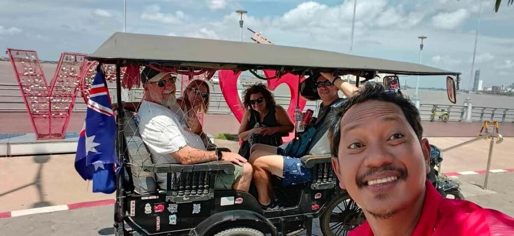 A group of people on a vehicle with a large 'V' decoration and Australian flag. 1