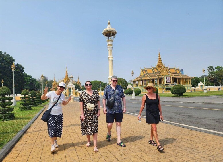 A group of people walking on a paved path with a temple in the background. 3