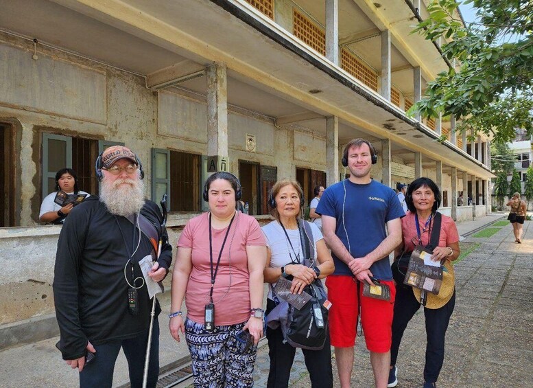 A group of people standing in front of a building with a balcony. 5