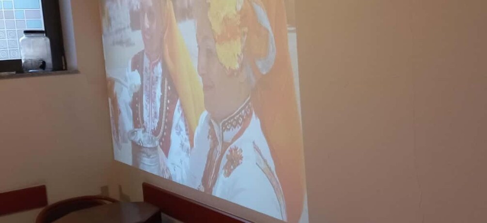 A projection of a person in traditional attire on a wall. 2