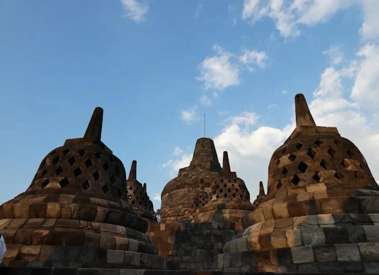 A series of ancient stone structures with conical roofs and intricate carvings. 5